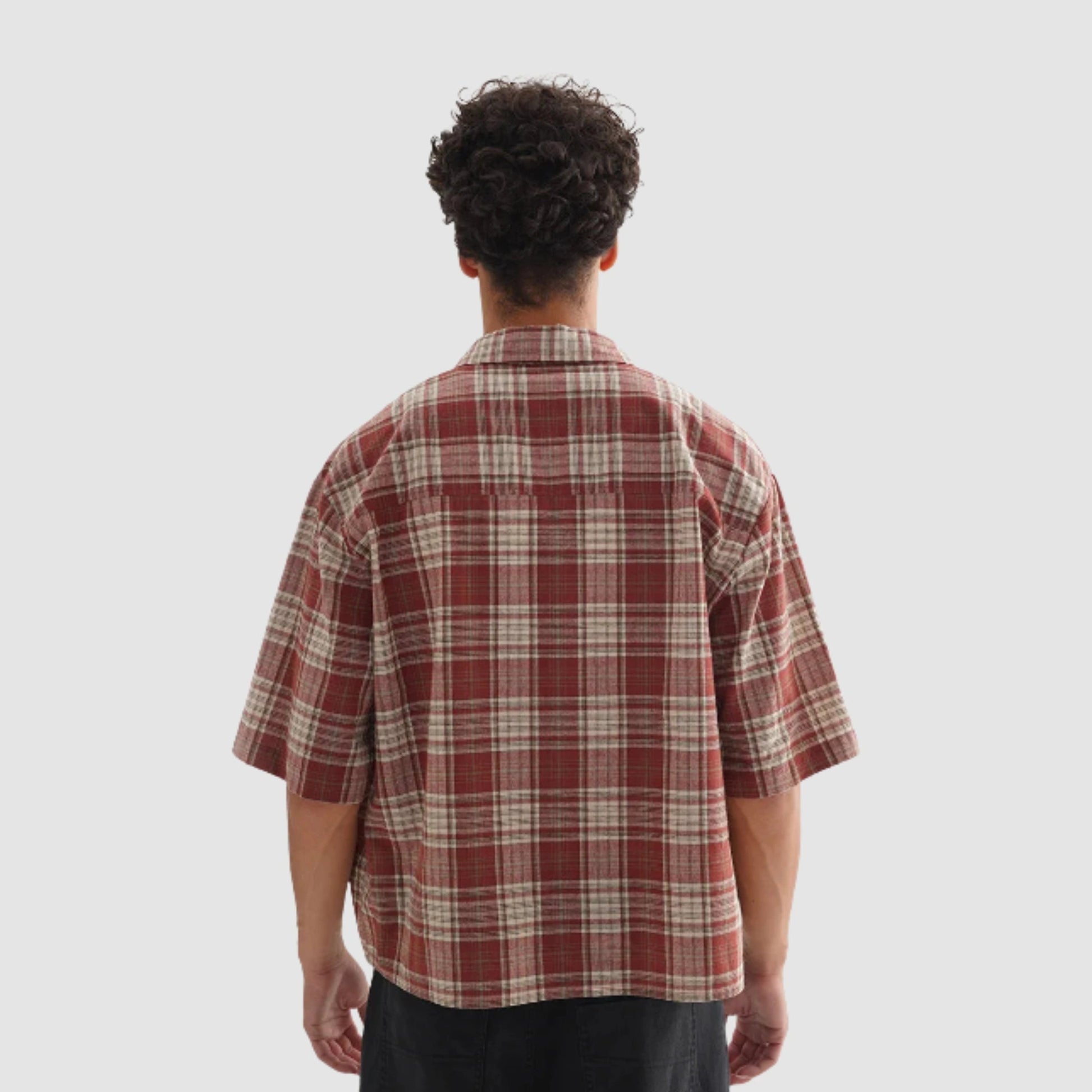 Un homme de dos, portant une chemise, avec un style streetwear.